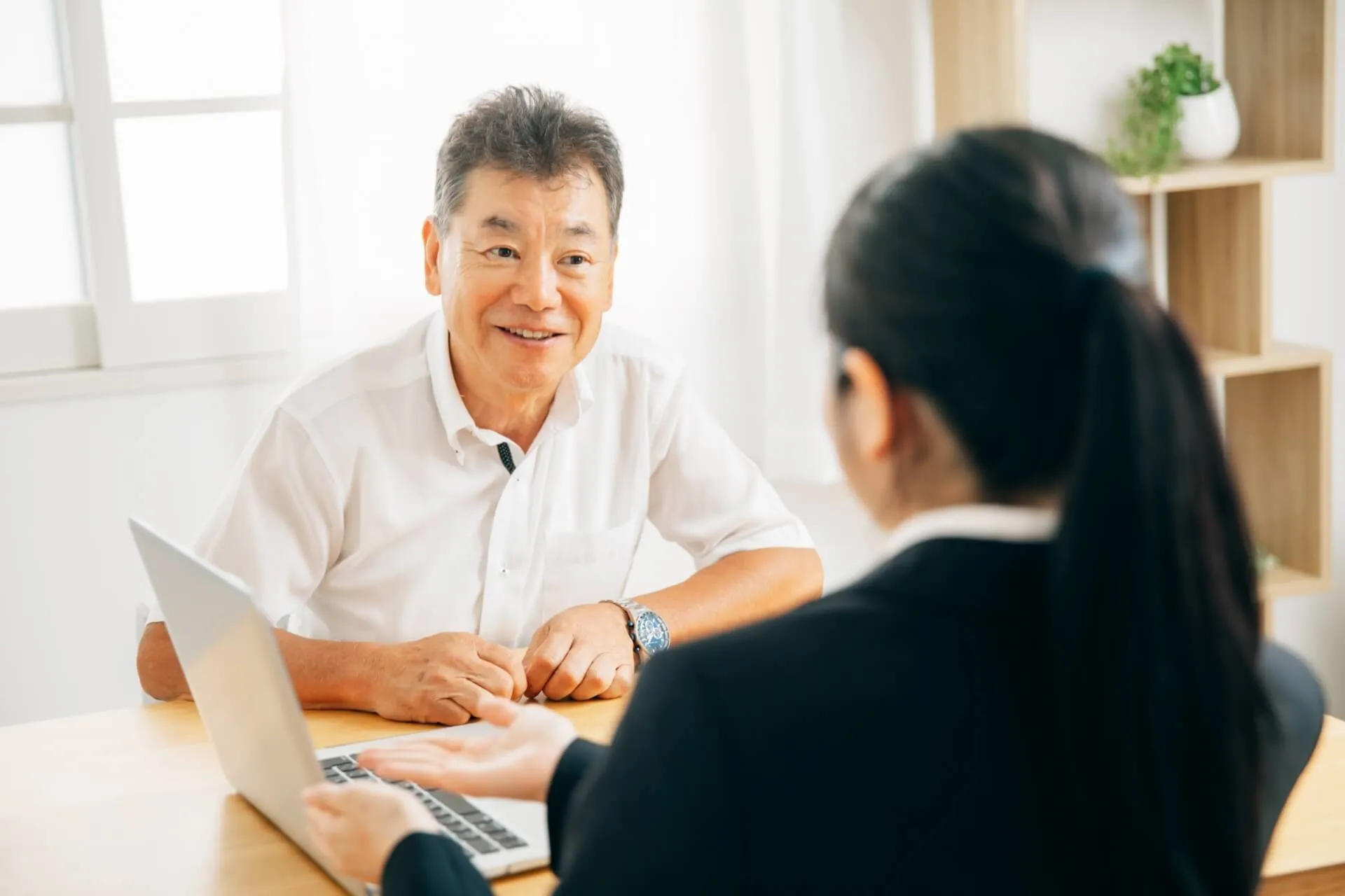 高齢男性が若い相談員と面談中